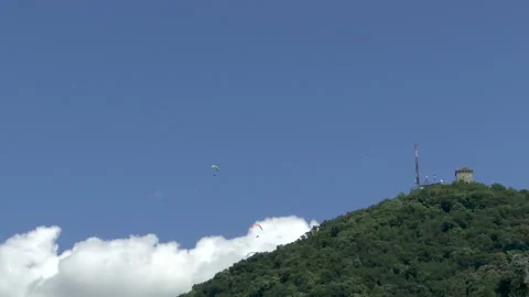 TIME LAPSE - a blue sky with a white cloud and dozens of paragliders 库存影片 156078866