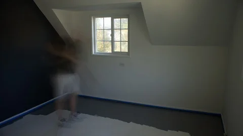 Time lapse blurred motion of a man painting over a white floor with gray paint Stock Footage 98906584