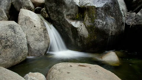 Time lapse of a blurry waterfall, pool of water and boulders on an overcast day 스톡 동영상 145985595