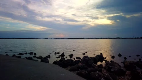 Time lapse boat passes by View over rocks in foreground and bay water looking so Stock Footage 262560883
