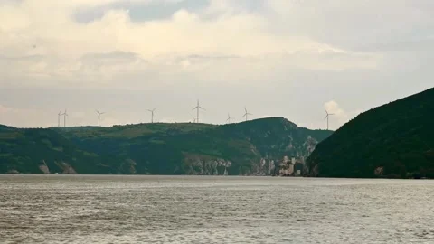 Time lapse of boat sailing on river and wind turbines in background on a hill Stock Footage 263144990