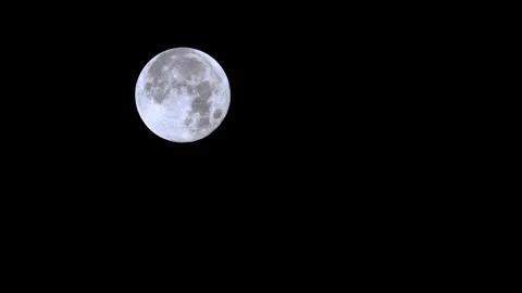 Time-lapse of a bright full moon moving downward against a black background 動画素材 330886289