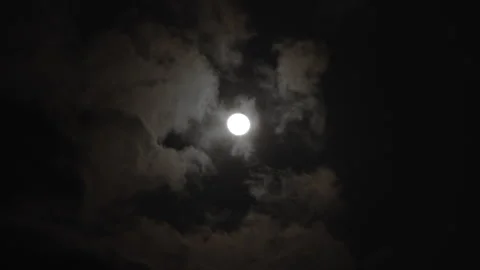 Time lapse of a bright full moon shining through fast-moving clouds at night Stock Footage 341483235