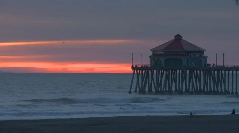 Time Lapse of a bright orange sunset over the pier in Huntington Beach, CA. Video stock 59735191