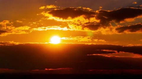 Time Lapse Bright Orange Sunset Sun Sets Behind the Clouds Vídeo Stock 219779314