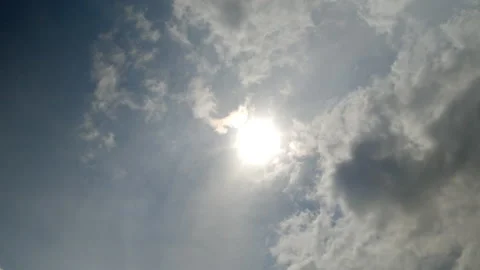 Time lapse bright sun and fast moving cumulus clouds cover the sun. Video stock 197768187