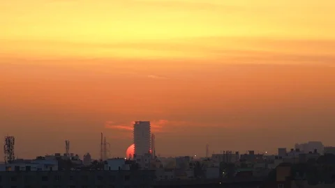 Time lapse of bright sunrise behind a building/ infrastructure - Bangalore India Vidéo 104646691