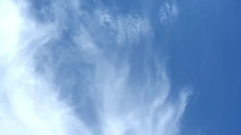 Time lapse of bright white summer cloud moving through a light blue sky Stock Footage 323472292