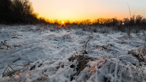 Time lapse. Bright yellow-orange sunset in a snowy field. Stock Footage 116599611