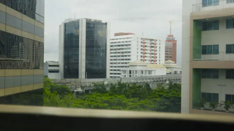 Time-lapse of BTS skytrain near MBK Center between condo towers Stock Footage 346213147