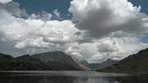 Time lapse of building storm clouds above a large lake surrounded by mountains Stock Footage 246865060