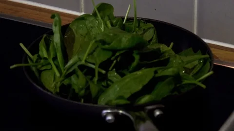 Time lapse of butter melting in pan of wilted spinach Stock Footage 98981153