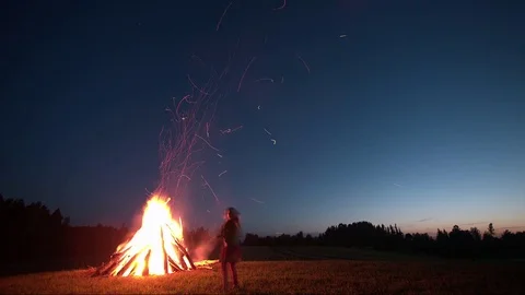 Time-lapse of camp fire on St. John's Day in meadow with sunset Stock Footage