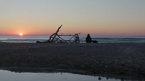 Time-lapse captures breathtaking beauty of a sunrise on beach, man arrives Video stock 233166825