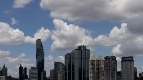 A time-lapse captures clouds drifting gracefully over Bangkoks skyscrapers .. Video stock 318472510
