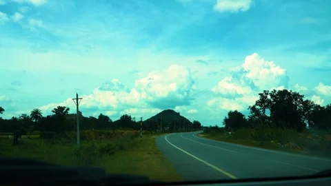 Time-lapse car mirror shot featuring moving vehicles, scenic clouds, and a fores Stock Footage 321861867