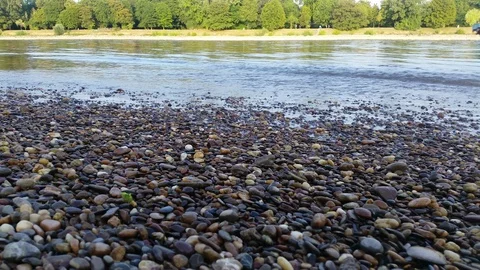 Time lapse of a cargo ship passing by the gravel shore of the Rhine river Stock Footage 93823336