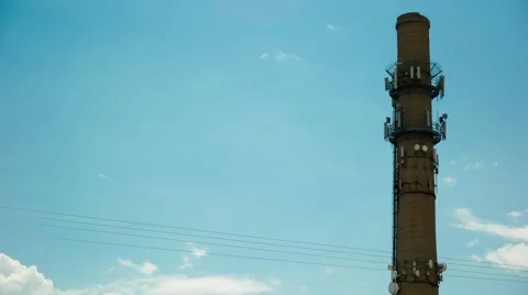 Time lapse of a cell phone tower built on an old smokestack with clouds. Stock Footage 40541296