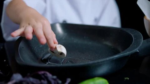Time lapse of cheerful boy cooking. He wears chefs suit and cap. Black Stock Footage 92556625