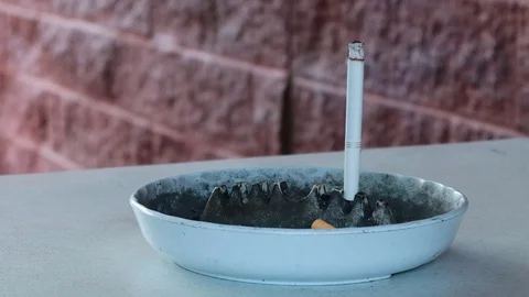 Time lapse of a cigarette kept upright on a white ash tray as it burns away Stock Footage 115269257