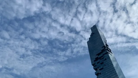 Time lapse of cirrocumulus clouds moving past skyscraper 스톡 동영상 121078724