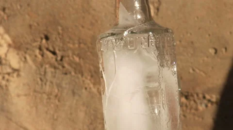 Time lapse clip of melting ice in broken glass bottle outside Stock Footage 45115968