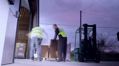 Time-lapse clip with warehouse workers loading pallets and moving them around Stock Footage