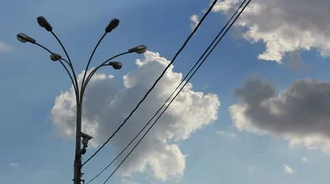 Time lapse clip of white fluffy clouds over blue sky and street lamp with wire Stock Footage 21316993