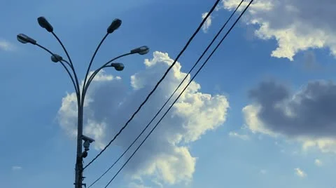 Time lapse clip of white fluffy clouds over blue sky and street lamp with wire Stock Footage 21317010