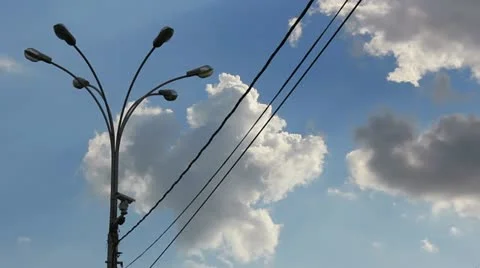Time lapse clip of white fluffy clouds over blue sky and street lamp with wire Stock Footage 21317025
