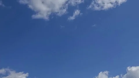 Time lapse clip of white fluffy clouds over blue sky, 4K Stock Footage 76380326
