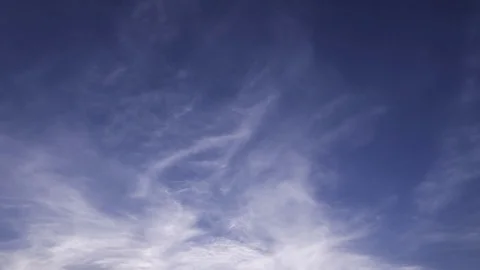 Time lapse clip of white fluffy clouds over blue sky, 4k Stock Footage 77257825