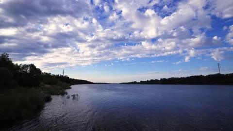Time lapse clip of white fluffy clouds over blue sky over river. Puffy fluffy Stock Footage 140840154