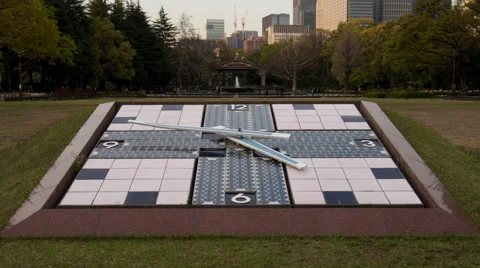 Time lapse of clock at Hibiya park in Tokyo. Camera tilts and pans up Stock Footage 49361535