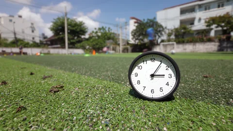 Time lapse clock ticking fast on soccer field, training blurred in background Stock Footage 345644944