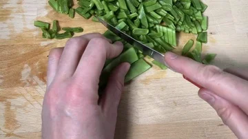 Time lapse close up of a hand cutting slices of green Italia taccola. Vídeos de archivo 86131880