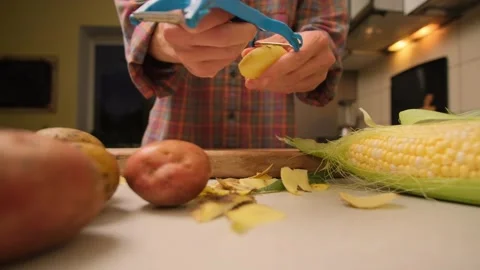 Time lapse close up peeling potatoes with peeler at home authentic kitchen Stock Footage 316403658
