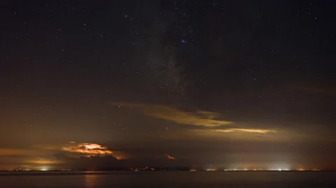 Time Lapse Cloud Lighting Milky Way Stars over Water and City Lights Stock Footage 53847776