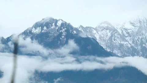 Time lapse of the cloud stream in front of the snow covered mountain peak  Stock Footage 168290635