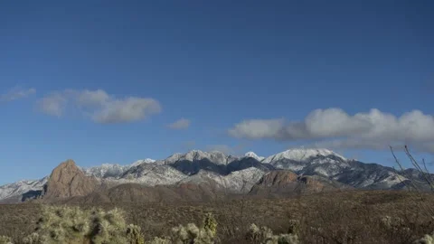Time lapse of clouds above dramatic desert mountains capped with snow Stock Footage 147492486