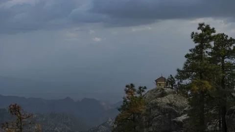 Time lapse of clouds above a fire lookout station on a mountain top Stock Footage 157600959