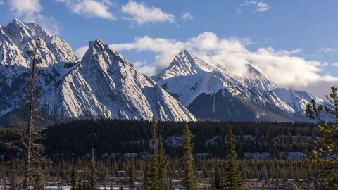 Time lapse of clouds above snowy mountain peaks and green forest Stock Footage 85252961