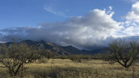 Time lapse of clouds above a sprawling ranch with scenic mountains Stock Footage 228658320