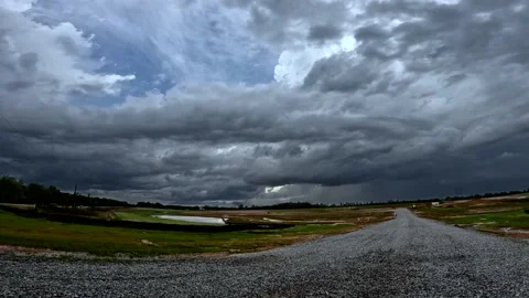 Time-lapse clouds and colorful land and gravel road in the country on a storm Stock Footage 176078931