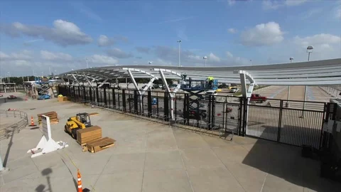 Time-lapse of clouds and construction of sports stadium from day to sunset Stock Footage 105423241