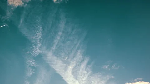 Time-lapse of clouds and a jet trail in the distance Stock-Footage 51429981