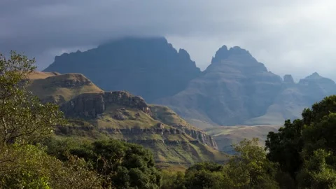 Time lapse Clouds and light over Cathkin peak in Maloti Drakensberg with trees Stock Footage 155387337