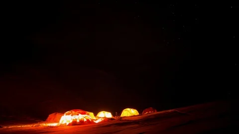 Time-lapse of clouds and northern lights floating over mountains and tents Stock Footage 113249697