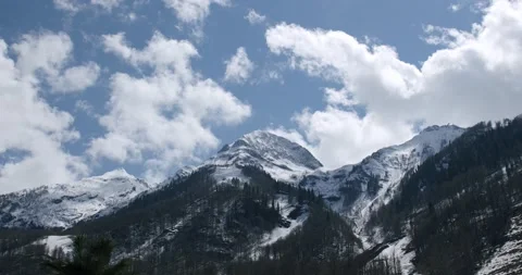 Time lapse of clouds and snow clad mountains while blue sky in the background Stock Footage 152324925