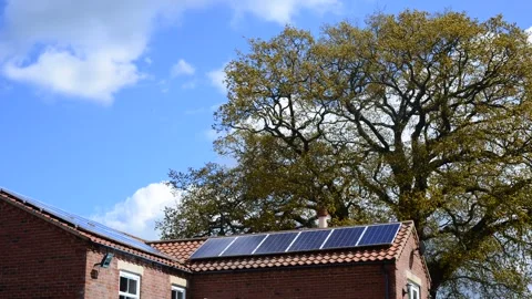 Time lapse clouds and solar panels on house roof by beautiful oak tree uk Stock Footage 170134779